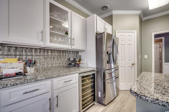 kitchen with white cabinets, light stone countertops, stainless steel fridge, and beverage cooler