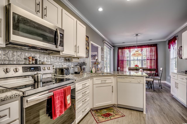 kitchen featuring appliances with stainless steel finishes, white cabinetry, kitchen peninsula, and light stone counters