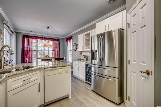 kitchen featuring sink, dishwasher, white cabinets, and stainless steel refrigerator with ice dispenser