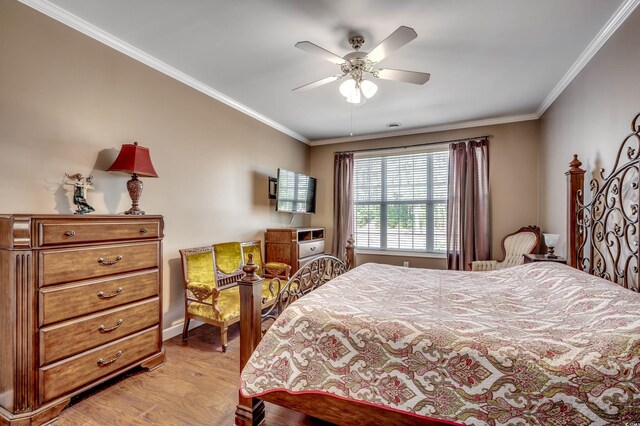 bedroom with light wood-type flooring, ceiling fan, and crown molding