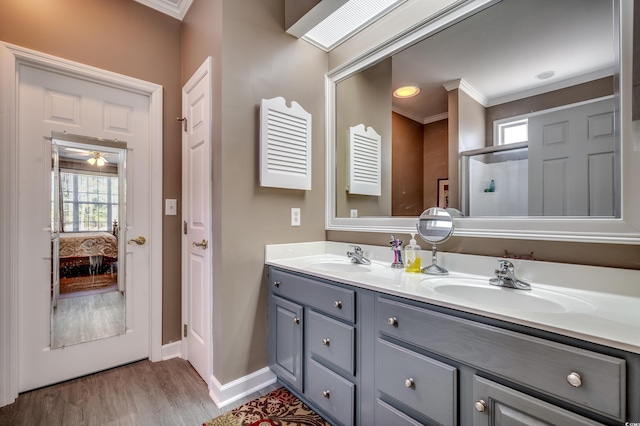 bathroom with ceiling fan, vanity, ornamental molding, and hardwood / wood-style flooring