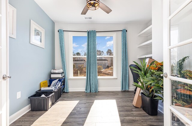 living area with ceiling fan and dark hardwood / wood-style flooring