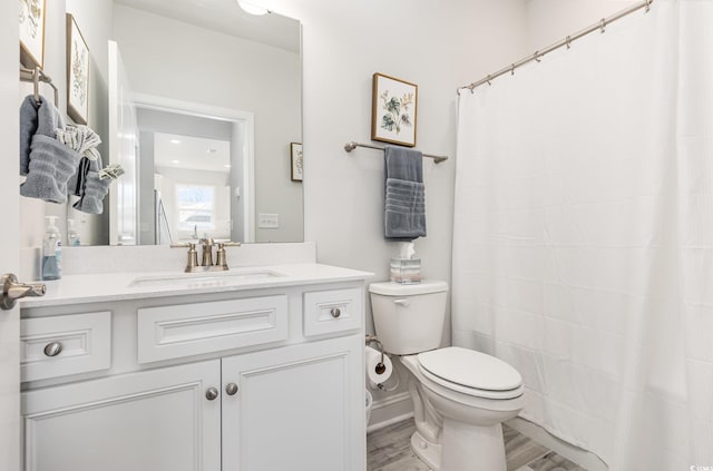 bathroom with wood-type flooring, vanity, and toilet