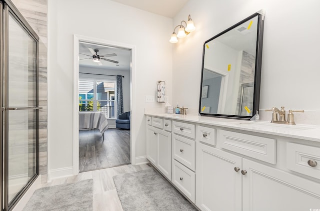 bathroom featuring ceiling fan, a shower with shower door, and vanity