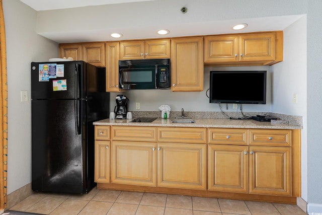 kitchen with light tile patterned floors, light stone countertops, black appliances, and recessed lighting