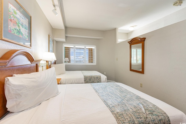 bedroom with track lighting and multiple windows