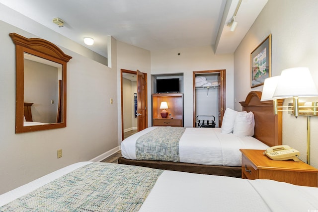 bedroom with track lighting and baseboards