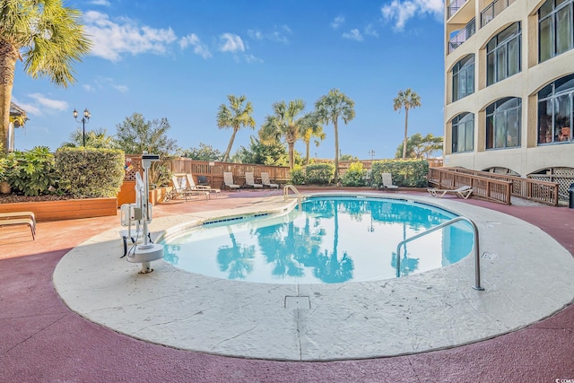 community pool featuring a patio and fence