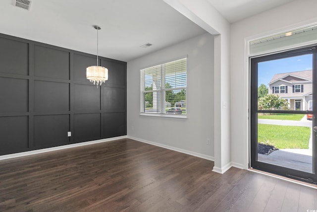 entryway with dark hardwood / wood-style flooring and an inviting chandelier