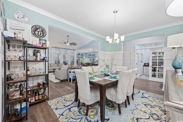 dining room with dark hardwood / wood-style floors, crown molding, ceiling fan with notable chandelier, and vaulted ceiling