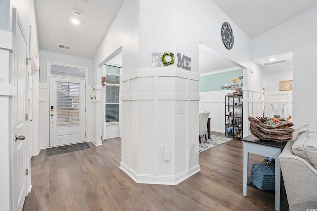 hall with light hardwood / wood-style flooring and high vaulted ceiling