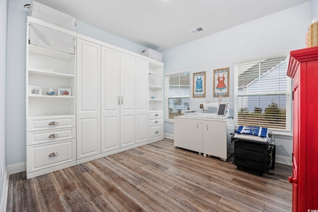 clothes washing area with washer and dryer, dark hardwood / wood-style floors, and cabinets