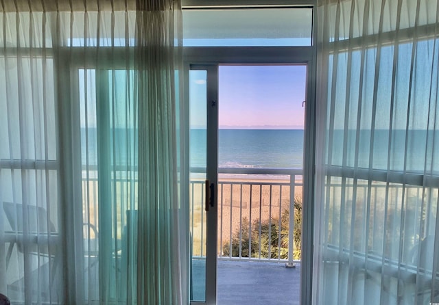 doorway featuring a view of the beach and a water view