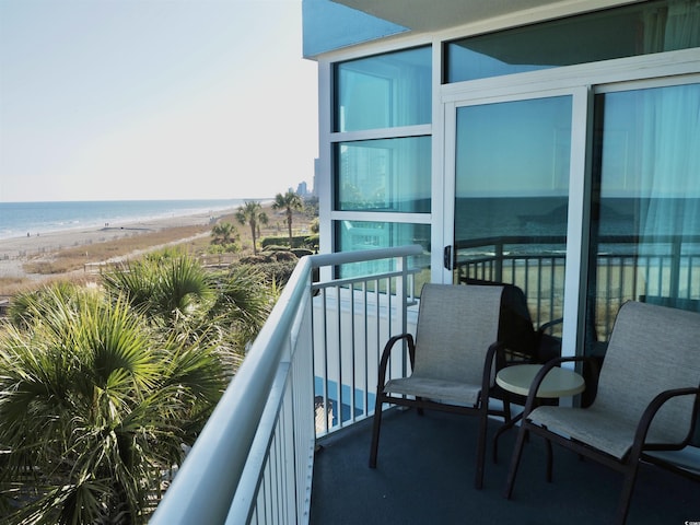 balcony featuring a water view and a view of the beach