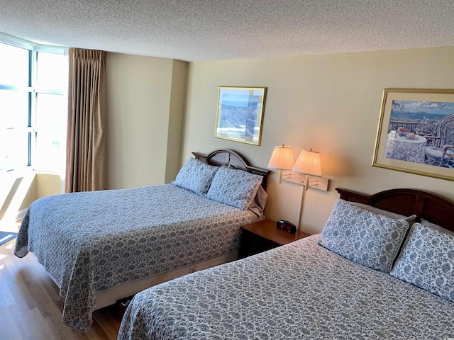 bedroom with a textured ceiling and wood finished floors