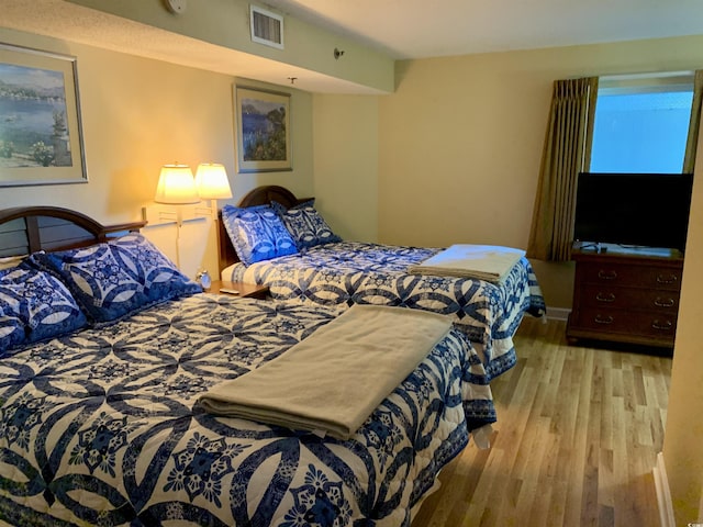 bedroom with light wood-style flooring and visible vents