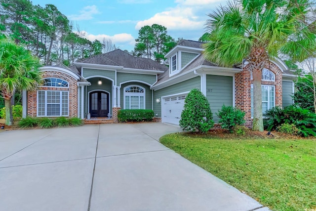 view of front of home with a garage, a front yard, and french doors