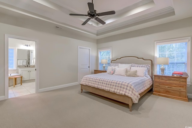 carpeted bedroom featuring ceiling fan, a raised ceiling, sink, and connected bathroom