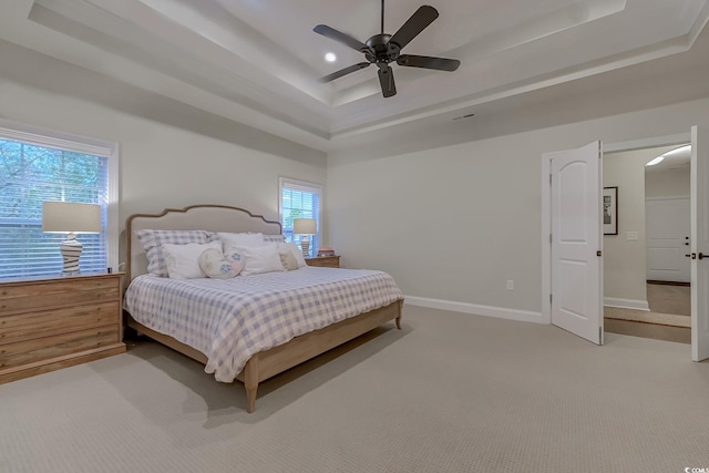 bedroom with a tray ceiling, ceiling fan, and carpet