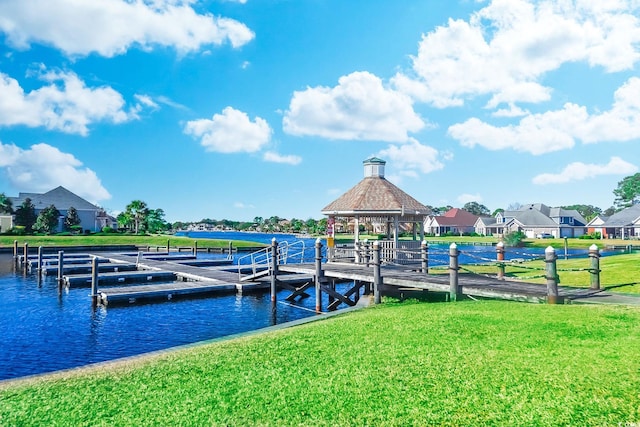 view of dock featuring a gazebo, a lawn, and a water view