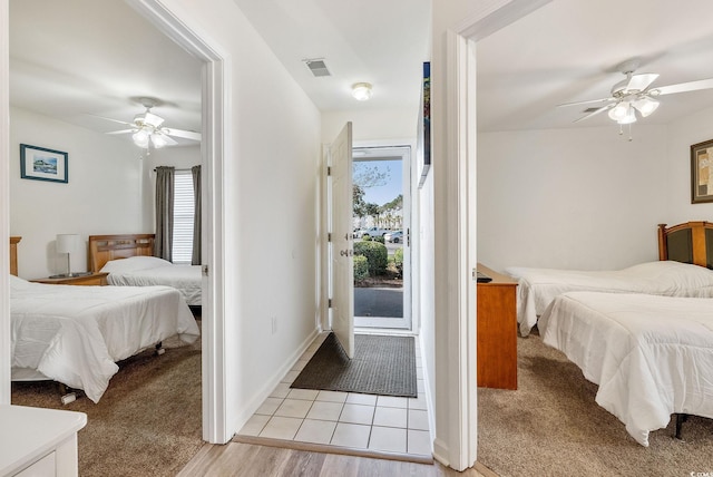 tiled bedroom featuring multiple windows and ceiling fan