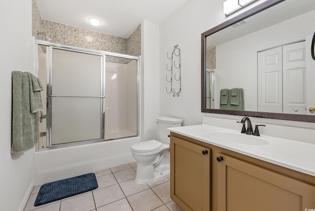 full bathroom with shower / bath combination with glass door, tile patterned floors, vanity, and toilet