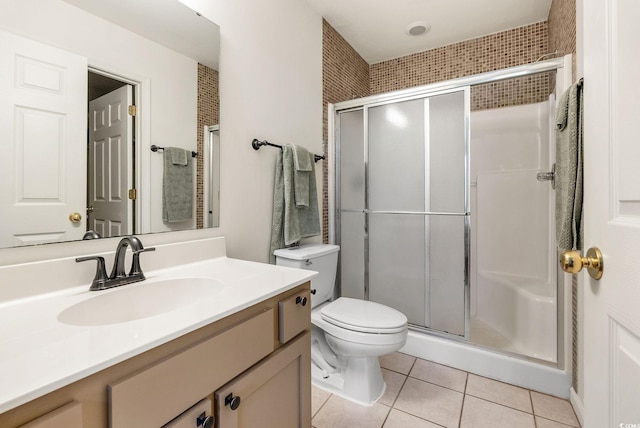 bathroom featuring tile patterned flooring, vanity, a shower with shower door, and toilet