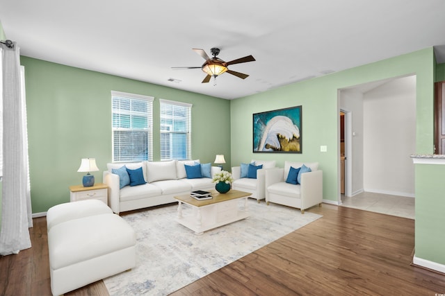 living room featuring wood-type flooring and ceiling fan