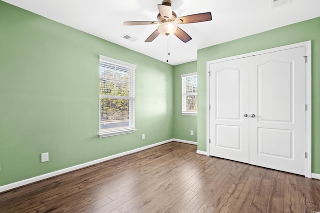 unfurnished bedroom with ceiling fan, a closet, and hardwood / wood-style floors