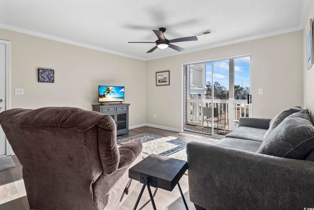 living room with ceiling fan, crown molding, wood-type flooring, and a textured ceiling