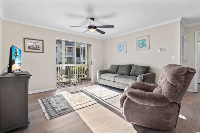 living room with crown molding, ceiling fan, dark hardwood / wood-style floors, and a textured ceiling