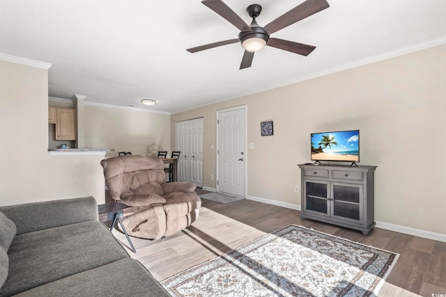 living room featuring dark hardwood / wood-style flooring, ceiling fan, and ornamental molding