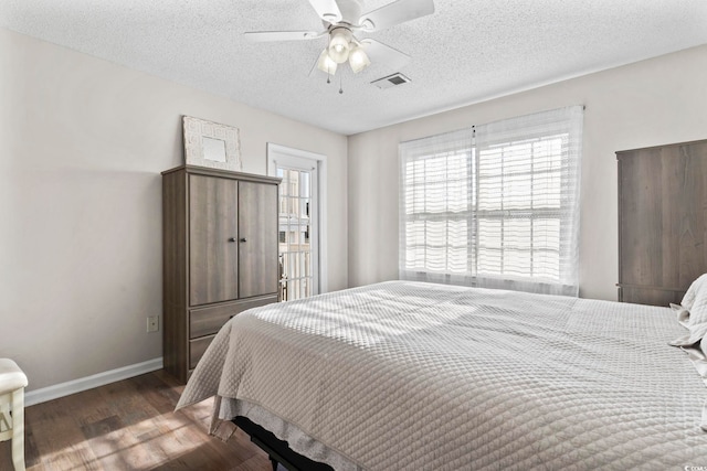 bedroom featuring ceiling fan, dark hardwood / wood-style flooring, and a textured ceiling