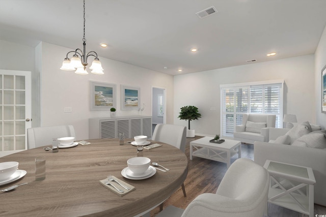 dining space featuring dark hardwood / wood-style flooring and a notable chandelier