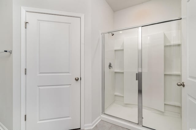 bathroom featuring tile patterned floors and a shower with door