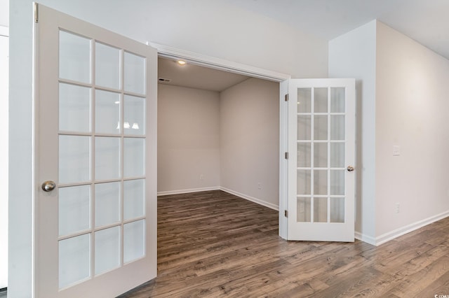 spare room featuring french doors and dark hardwood / wood-style flooring