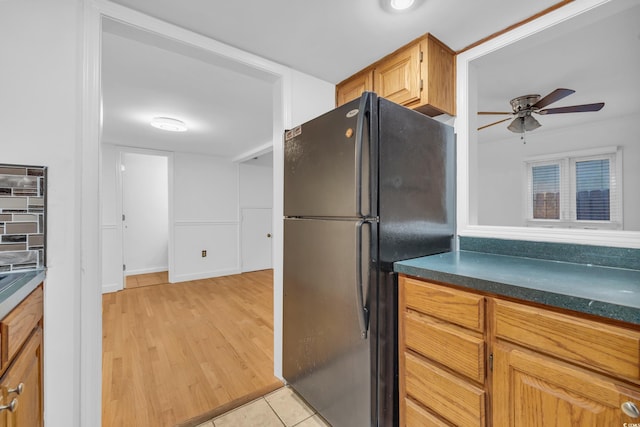 kitchen with black refrigerator, light tile patterned floors, and ceiling fan