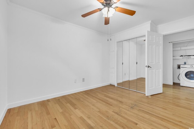 unfurnished bedroom featuring ceiling fan, crown molding, hardwood / wood-style flooring, and washer / clothes dryer