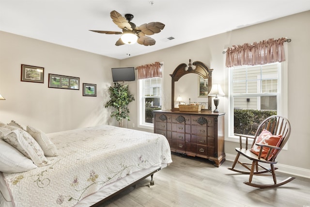 bedroom featuring multiple windows, light wood-type flooring, and ceiling fan