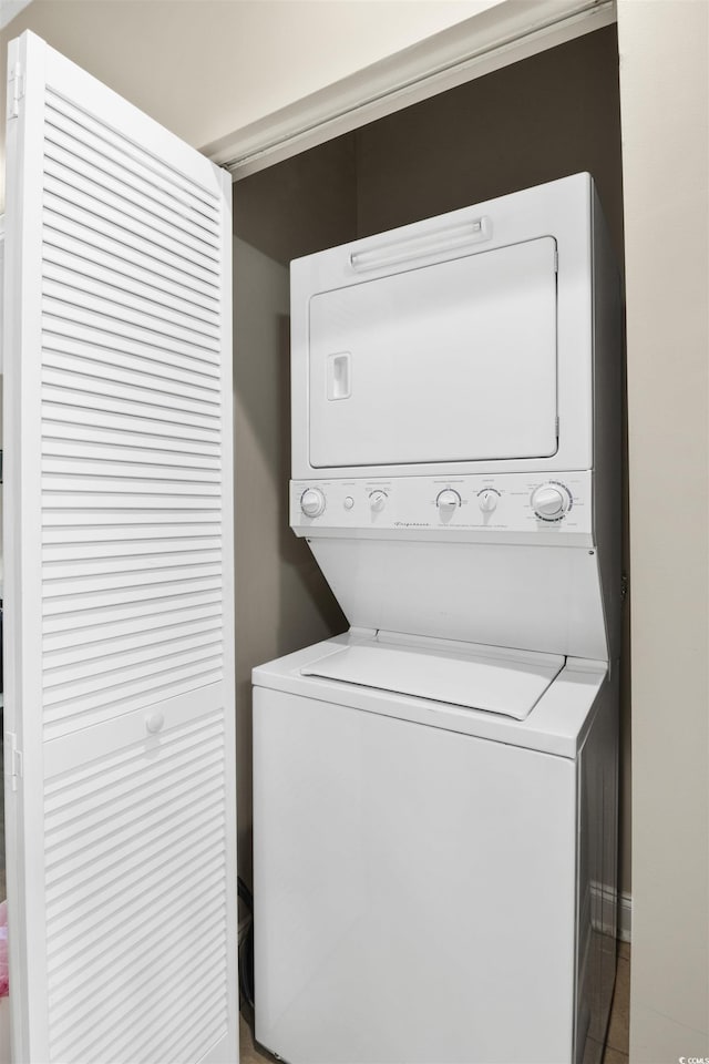 clothes washing area featuring stacked washer / drying machine