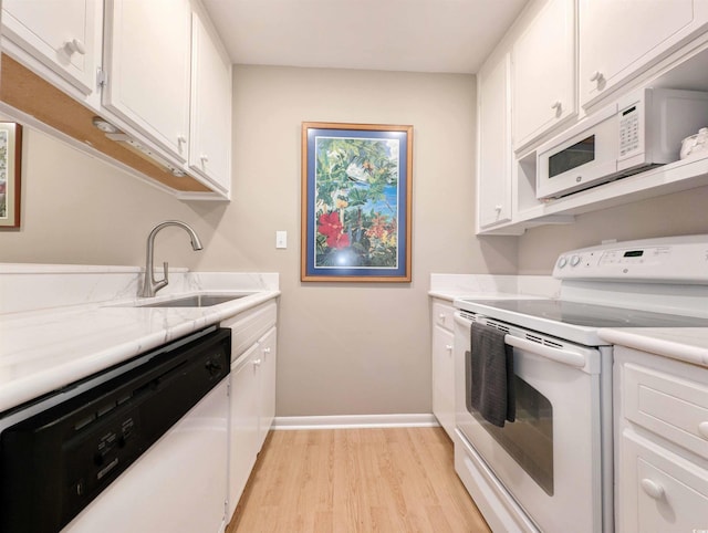 kitchen with light stone countertops, sink, light hardwood / wood-style floors, white appliances, and white cabinets