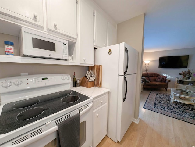 kitchen featuring white cabinets, light hardwood / wood-style floors, and white appliances