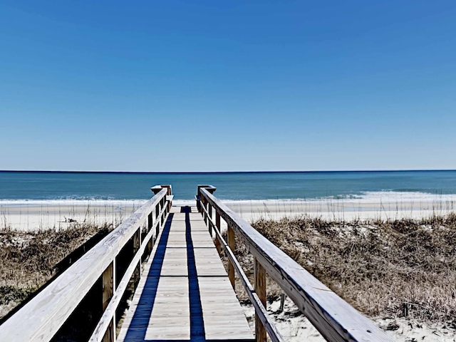 dock area with a water view and a view of the beach