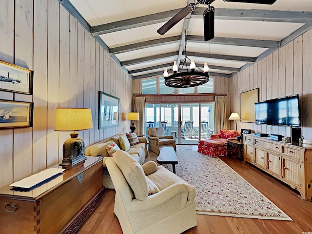 living room with vaulted ceiling with beams, wood walls, light wood-type flooring, and a chandelier