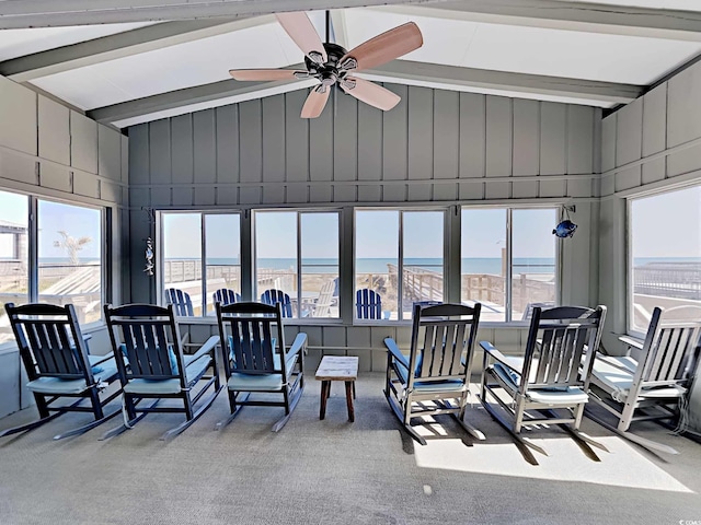 sunroom / solarium with ceiling fan and a water view