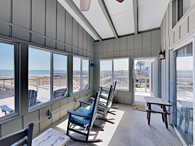 sunroom / solarium featuring ceiling fan, lofted ceiling with beams, and a water view