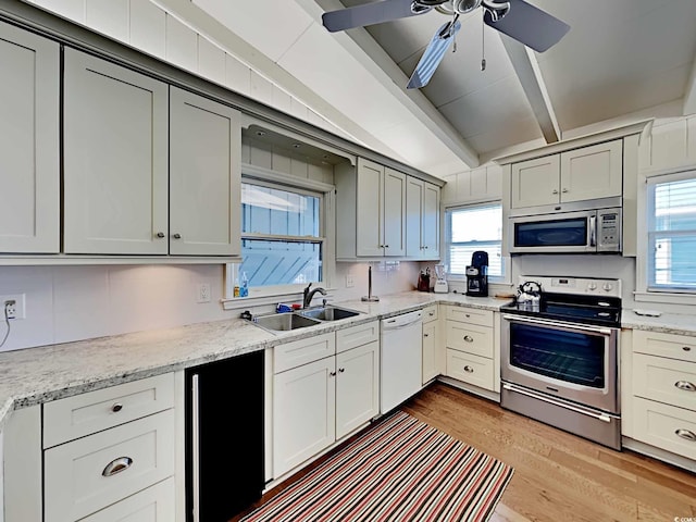 kitchen featuring sink, ceiling fan, beamed ceiling, light hardwood / wood-style floors, and stainless steel appliances