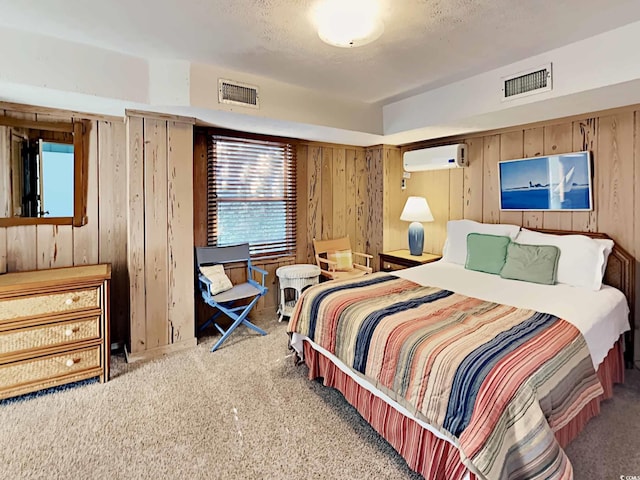 carpeted bedroom featuring a wall unit AC, a textured ceiling, and wooden walls