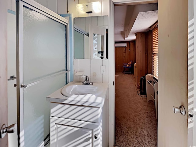 bathroom featuring a wall mounted air conditioner, vanity, an enclosed shower, and wooden walls