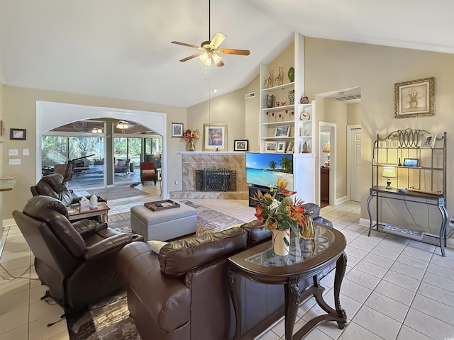 living room featuring ceiling fan, a fireplace, light tile patterned flooring, and vaulted ceiling